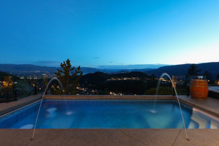 Infinity pool with water features at dusk above the Okanagan valley, Kelowna