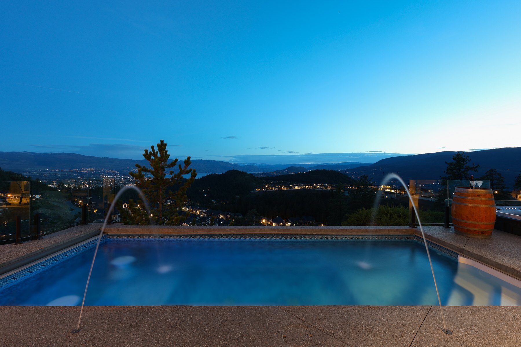 Infinity pool with water features at dusk above the Okanagan valley, Kelowna