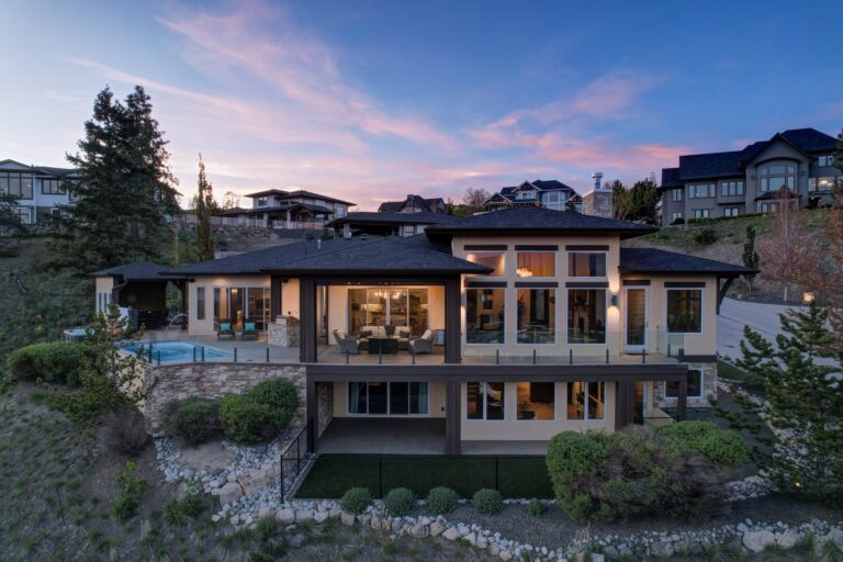 Recently built hillside home lit at twilight, Kelowna