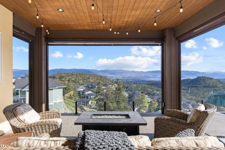 Covered outdoor lounge with a wood ceiling and valley view, Kelowna home