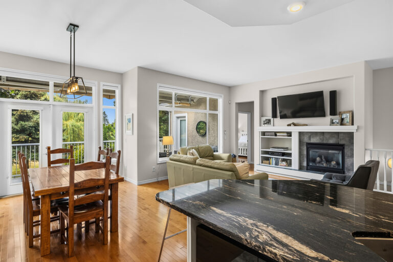 Open plan kitchen, dining and living room with fireplace in a Kelowna single family home